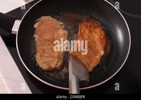 Schnitzel kochen in einer Pfanne auf dem Herd, Blick von oben Stockfoto