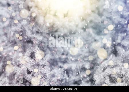 Mit Sonnenlicht geschmückter Weihnachtsbaum in einem verschneiten Winterwald, mit fallendem Schnee und einem weichen, verschwommenen Hintergrund. Stockfoto