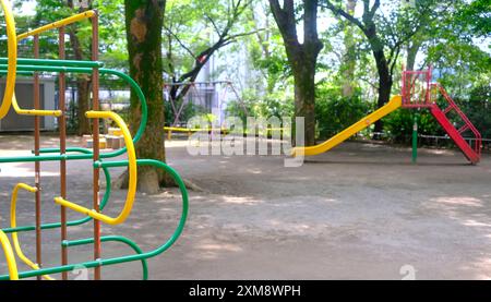 Die gelbe, fröhliche Rutsche und der Kletterrahmen für Kinder und Kinder auf dem japanischen Spielplatz Stockfoto