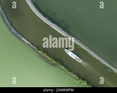 Ein Schiff, das vom Hafen in den Balaton fährt. Das Wasser des Sees ist zweifarbig Stockfoto