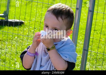 Lulworth, Dorset, Großbritannien. Juli 2024. Kleinkind mit unordentlichem Gesicht isst Eis beim Camp Bestival, 26. Juli 2024, Credit: Dawn Fletcher-Park/Alamy Live News Stockfoto