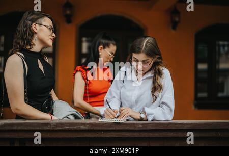 Geschäftsfrauen, die ein Treffen im Freien veranstalten und sich Notizen in einer ungezwungenen Umgebung machen Stockfoto
