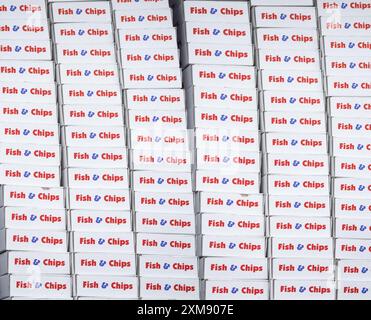 Ein Hintergrund aus mehreren Fish & Chips Take-away-Boxen in Einem britischen „Chippy“ Stockfoto