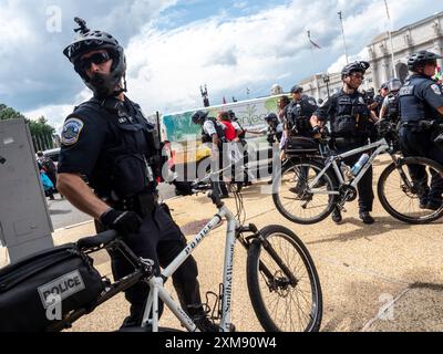 Washington, District of Columbia, USA. Juli 2024. Die Fahrradpolizei blockiert jeden, der versucht, einen verhafteten palästinensischen Demonstranten zu erreichen. Hier, in einem roten Hemd gekleidet, wird er von der Polizei weggeführt. (Credit Image: © Sue Dorfman/ZUMA Press Wire) NUR REDAKTIONELLE VERWENDUNG! Nicht für kommerzielle ZWECKE! Stockfoto