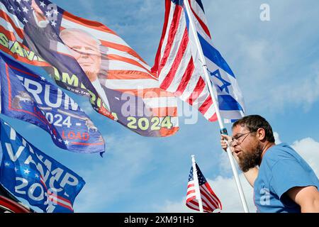 West Palm Beach, USA. Juli 2024. Matt Dorffman aus West Palm Beach hält am Freitag, den 26. Juli 2023, einen Fahnenmast mit israelischen und US-amerikanischen Flaggen, während er ihn an seinem Auto entlang des Southern Boulevard auf der Route nach Mar-a-Lago in Palm Beach, Florida, befestigt. Der republikanische Präsidentschaftskandidat Donald Trump wird sich mit dem israelischen Premierminister Benjamin Netanjahu treffen. (Foto: Amy Beth Bennett/South Florida Sun Sentinel/TNS/SIPA USA) Credit: SIPA USA/Alamy Live News Stockfoto