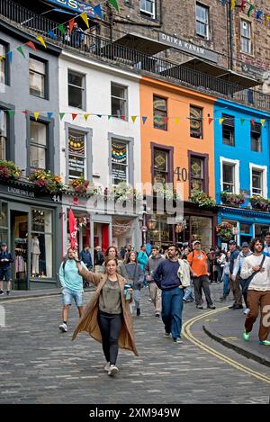 Fremale Reiseleiterin mit einem Schirm führt ihre Gruppe entlang der Victoria Street in Edinburghs Altstadt. Stockfoto