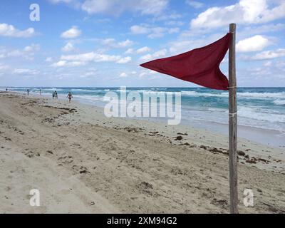 Eine rote Flagge fliegt an einem kubanischen Strand und warnt vor gefährlichen Bedingungen. Stockfoto