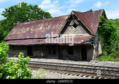 Old Limestone Train Depot befindet sich neben alten Gleisen in Kalkstein, Tennessee. Blechdach und Lebkuchenholzarbeiten sind verfallen. Stockfoto