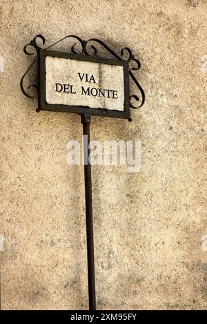 Ein altes Metallic-Stangenschild mit einem Straßennamen darauf im Dorf Rasiglia, Italien. Stockfoto