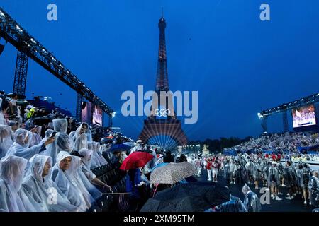 Symbolbild / Themenfoto Eiffelturm mit Beleuchtung und olympischen Ringen, davor Zuschauer am Trocadero im Regen mit Schirm und Regenponcho im Regen, FRA, Olympische Spiele Paris 2024, Eroeffnungsfeier, Eröffnungszeremonie, 26.07.2024 Foto: Eibner-Pressefoto/Roger Buerke Stockfoto