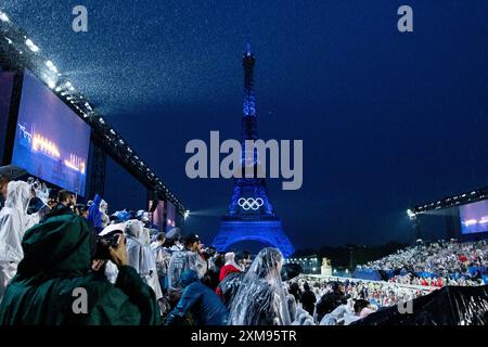 Symbolbild / Themenfoto Eiffelturm mit Beleuchtung und olympischen Ringen, davor Zuschauer am Trocadero im Regen mit Schirm und Regenponcho im Regen, FRA, Olympische Spiele Paris 2024, Eroeffnungsfeier, Eröffnungszeremonie, 26.07.2024 Foto: Eibner-Pressefoto/Roger Buerke Stockfoto