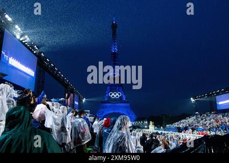 Symbolbild / Themenfoto Eiffelturm mit Beleuchtung und olympischen Ringen, davor Zuschauer am Trocadero im Regen mit Schirm und Regenponcho im Regen, FRA, Olympische Spiele Paris 2024, Eroeffnungsfeier, Eröffnungszeremonie, 26.07.2024 Foto: Eibner-Pressefoto/Roger Buerke Stockfoto