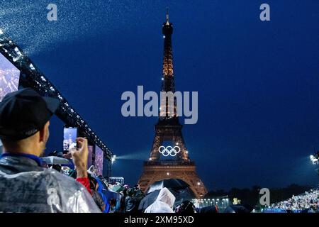 Symbolbild / Themenfoto Eiffelturm mit Beleuchtung und olympischen Ringen, davor Zuschauer am Trocadero im Regen mit Schirm und Regenponcho im Regen, FRA, Olympische Spiele Paris 2024, Eroeffnungsfeier, Eröffnungszeremonie, 26.07.2024 Foto: Eibner-Pressefoto/Roger Buerke Stockfoto