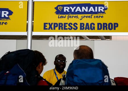 Passanten warten beim Selbsteinchecken und der Selbsteinzug wird am Ryanair Check-in-Schalter am Flughafen London Stansted gesehen. Der London Stansted Airport ist ein internationaler Flughafen, der etwa 30 Meilen nördlich von Central London liegt. Es ist einer der großen Flughäfen, die London ansteuern. Stockfoto