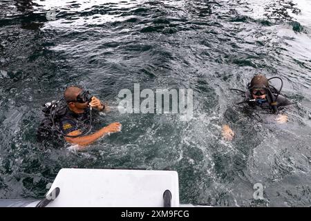 VIRGINIA BEACH, Va. — Ein Techniker der US Navy für die Entsorgung von Sprengkörpern (EOD) und ein Unterwasser-Medicial Officer (UMO) von der Sprengstoffverordnungs-Gruppe (EODGRU) 2 Tauchgang im Atlantik mit dem in sich geschlossenen Unterwasser-Atemgerät (SCUBA), 24. Juli 2024. EODGRU 2 führt regelmäßige Tauchkurse durch, um das EOD-Personal in Bezug auf seine Qualifikationen auf dem neuesten Stand zu halten. (Foto der U.S. Navy von Mass Communications Specialist 2nd Class Jackson Adkins) Stockfoto