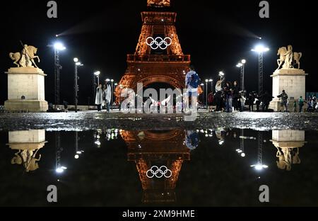 Paris, Frankreich. Juli 2024. Olympia, Paris 2024, Eröffnungszeremonie der Olympischen Sommerspiele spiegelt sich der beleuchtete Eiffelturm mit den Olympischen Ringen in einer Pfütze wider. Quelle: Sven Hoppe/dpa/Alamy Live News Stockfoto