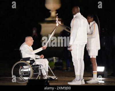 (240726) -- PARIS, 26. Juli 2024 (Xinhua) -- Charles Coste (L), der älteste französische Olympiasieger, überreicht die olympische Flamme an die Fackelträger Marie-Jose Perec (R) und Teddy Riner während der Eröffnungszeremonie der Olympischen Spiele 2024 in Paris, Frankreich, 26. Juli 2024. (Xinhua/Du Yu) Stockfoto