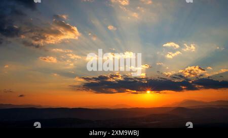 Morgenlicht mit Blick auf die Berge, goldener Sonnenaufgang. Wunderschöne Landschaft mit blauem Himmel. Reiseziel . Himmelswolken bei Sonnenuntergang über dem Horizont, Stockfoto