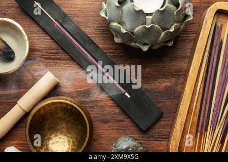 Flache Lagenkomposition mit Räucherstäbchen auf Holztisch. OM-Ligatur Stockfoto