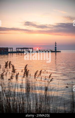 Sonnenaufgang am Ufer und Hafen eines Sees im Sommer. Farbenfroher Himmel mit weitem Blick auf den Horizont. Natürliche Landschaft am Yachthafen Tihany, See Stockfoto