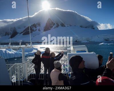 Touristen an Bord eines antarktischen Kreuzfahrtschiffs, die Fotos vom Lemaire Channel, Graham Land machen. Stockfoto