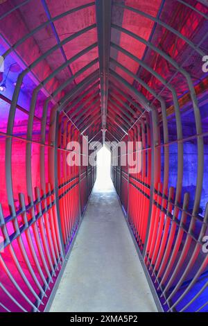 Ein langer Tunnel mit roter Beleuchtung und metallischen Strukturen vermittelt eine futuristische und industrielle Atmosphäre, Landschaftspark Duisburg Nord, Meiderich Stockfoto