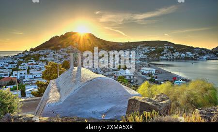 Agia Paraskevi Kapelle, kleine Kapelle bei Sonnenuntergang mit Blick auf eine Küstenstadt und das Meer im Hintergrund, Skala, Patmos, Dodekanes, griechische Inseln Stockfoto