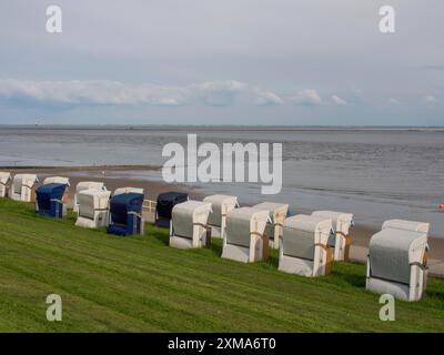 Liegereihe am Meer mit leicht bewölktem Himmel und einer Wiese im Vordergrund, wilhelmshaven, deutschland Stockfoto