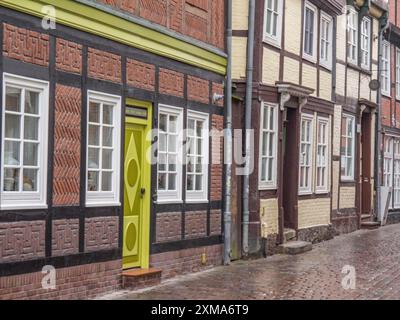 Fachwerkhäuser mit bunten Details und Kopfsteinpflasterstraße, grüne Haustür als Hingucker, stade, deutschland Stockfoto