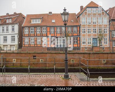 Fachwerkhäuser mit verschiedenen Ziegelfassaden entlang eines Kanals mit Straßenlaterne in einer Stadt, stade, deutschland Stockfoto