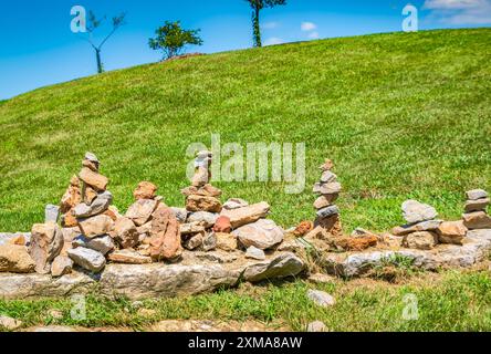 Gestapelte Steine auf einem grasbewachsenen Hügel Stockfoto