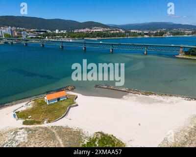 Küstenlandschaft mit einem weißen Sandstrand und einem kleinen Haus, im Hintergrund eine Brücke und eine Stadt, aus der Vogelperspektive, Ponte Eiffel, Brücke bei Gustave Stockfoto