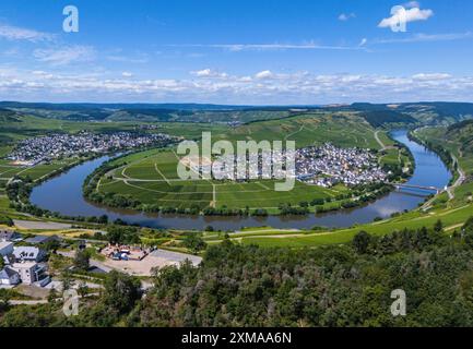 Panoramablick auf einen sich windenden Fluss umgeben von Weinbergen und einem Dorf mit blauem Himmel und Wolken im Hintergrund, Luftsicht, Mosel Stockfoto