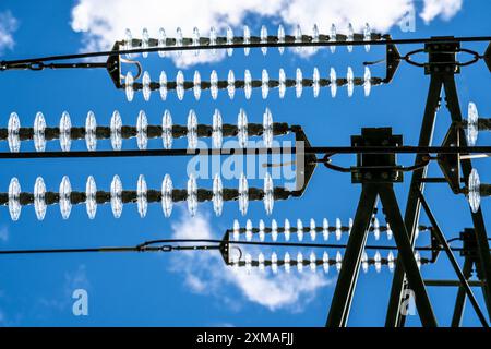 Isolatoren aus Glas an einer Hochspannungsleitung hängen sie als Aufhängevorrichtung zwischen dem Pylon und dem stromführenden, nicht isolierten Kabel an den Pylonen Stockfoto