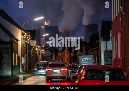 Das Dorf Vanikum, Teil der Gemeinde Rommerskirchen, Hauptstraße, dahinter das Braunkohlekraftwerk Neurath, bei Grevenbroich Stockfoto