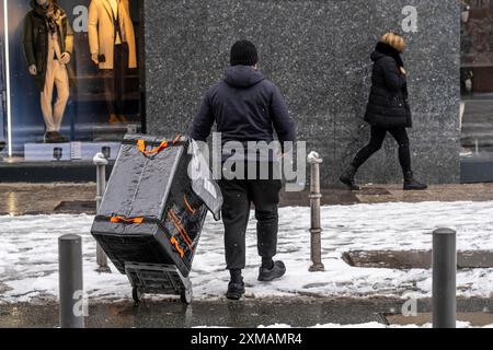 Winter in Frankfurt bringt der Mitarbeiter von Amazon eine Sendung zu Fuß in den Bankenbezirk Hessen Stockfoto