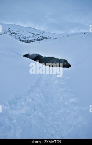 Pfad im Schnee führt zur Castner Cave, die an einem kalten Wintertag in Alaska eröffnet wird. Stockfoto