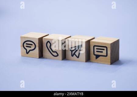 Kontaktieren Sie uns per E-Mail oder Telefon! Modernes Geschäftskonzept mit weißen Symbolen, die Kommunikationsmethoden symbolisieren. Stockfoto