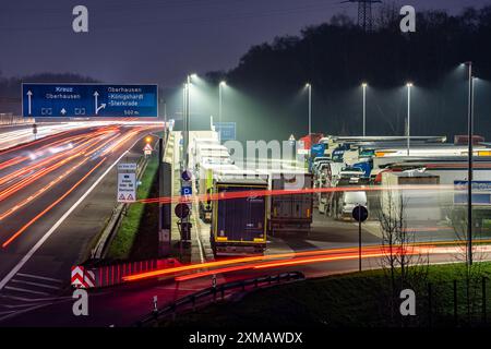 Starker Verkehr auf der A2 an der Raststätte Schwarze Heide, Bottrop, überfüllter Parkplatz für LKW am Abend, Bottrop, Nordrhein-Westfalen Stockfoto