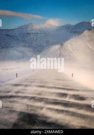 Starker Schneesturm in Island, schnelle Winde, die den Schnee auf der Straße wehen, schlechte Sicht, Fahrt durch Island Stockfoto