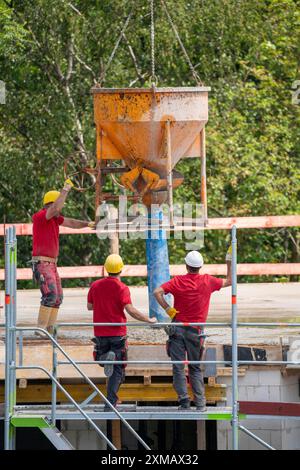Baustelle, Betonieren, Decke eines Gebäudes wird betoniert, der Beton wird mittels einer Betonbombe auf die Stahlbetonmatten gelegt Stockfoto