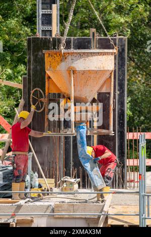 Baustelle, Betonieren, Decke eines Gebäudes wird betoniert, der Beton wird mittels einer Betonbombe auf die Stahlbetonmatten gelegt Stockfoto