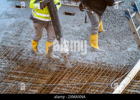 Baustelle, Beton, Boden, Decke für ein Gebäude wird betoniert, der Beton wird auf die Stahlbetonmatten gepumpt Stockfoto