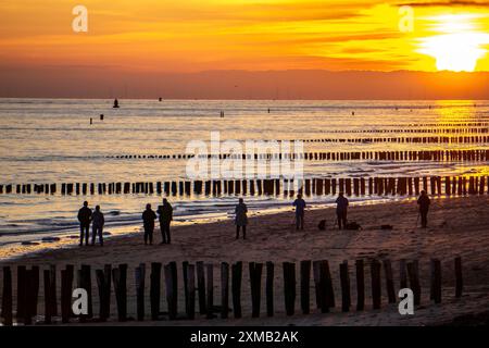 Sonnenuntergang am Strand von Zoutelande, Strand mit Holzpfahlbrüchen, Zeeland, Niederlande Stockfoto