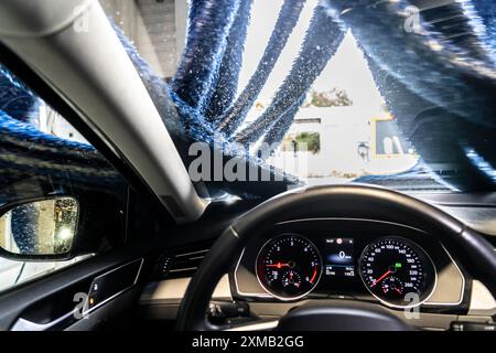 Auto in einer automatischen Waschanlage, Autowaschtunnel, Trocknung, mit heißer Luft und rotierenden Textiltüchern Stockfoto