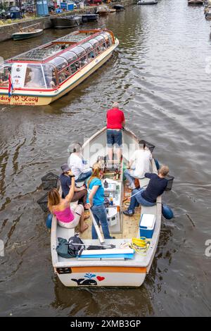 Plastikwalboot in einem Kanal in Amsterdam, Passagiere fischen Plastikmüll aus den Kanälen, fahren durch die Kanäle von Amsterdam, sammeln Abfall Stockfoto