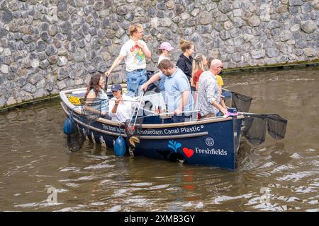 Plastikwalboot in einem Kanal in Amsterdam, Passagiere fischen Plastikmüll aus den Kanälen, fahren durch die Kanäle von Amsterdam, sammeln Abfall Stockfoto