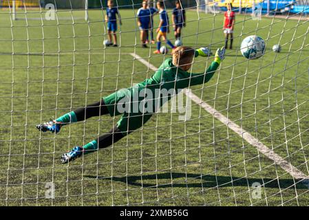 Ein schwarz-weißer Fußball, der durch einen kräftigen Schuss angetrieben wird und das Netz durchbricht, um ein perfektes Tor zu erzielen. Das wulstige Netz betont den Aufprall und die Qualität Stockfoto