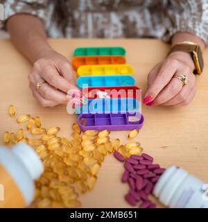 Organisator für Pillen, Vitamine und Nahrungsergänzungsmittel auf hellblauem Hintergrund. Pflegekonzept Stockfoto