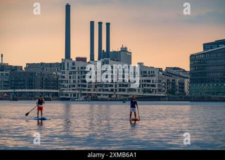 Stand-up-Paddler auf dem Sydhavnen, hinter der Bryggebroen-Brücke, Kopenhagen, Dänemark Stockfoto